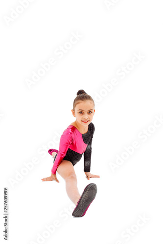 Little girl gymnast sitting in the splits. Isolated on white.