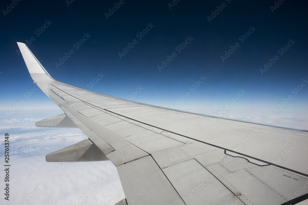 Aircraft wing during the flight with blue sky Aircraft wing during the flight with blue sky