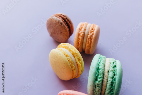 Composition of delicious macaroons on purple background
