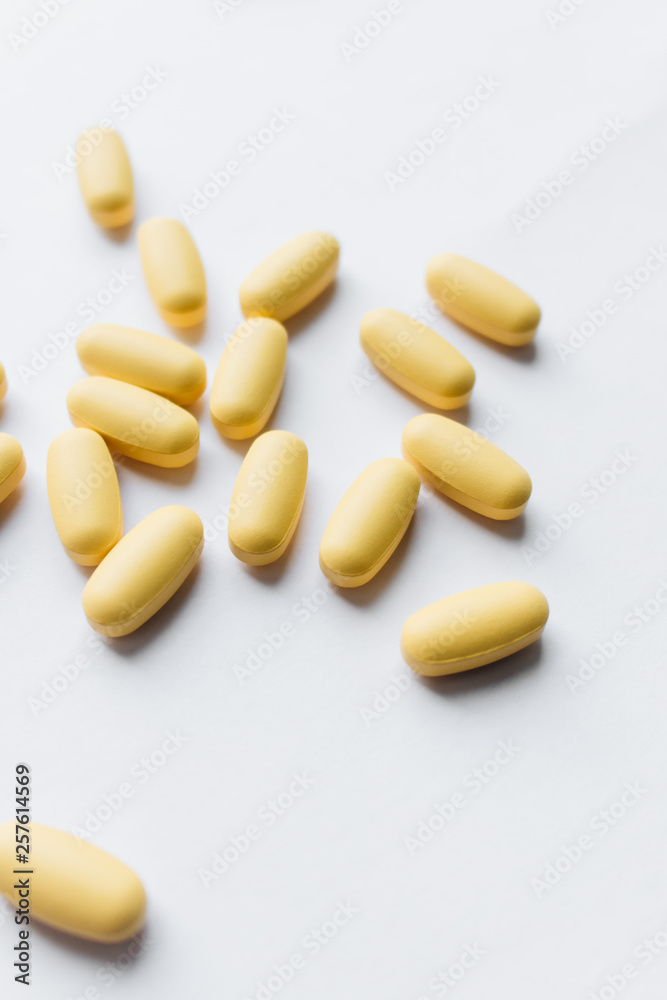 Scatterded yellow pills on white background Scatterded yellow pills on white background