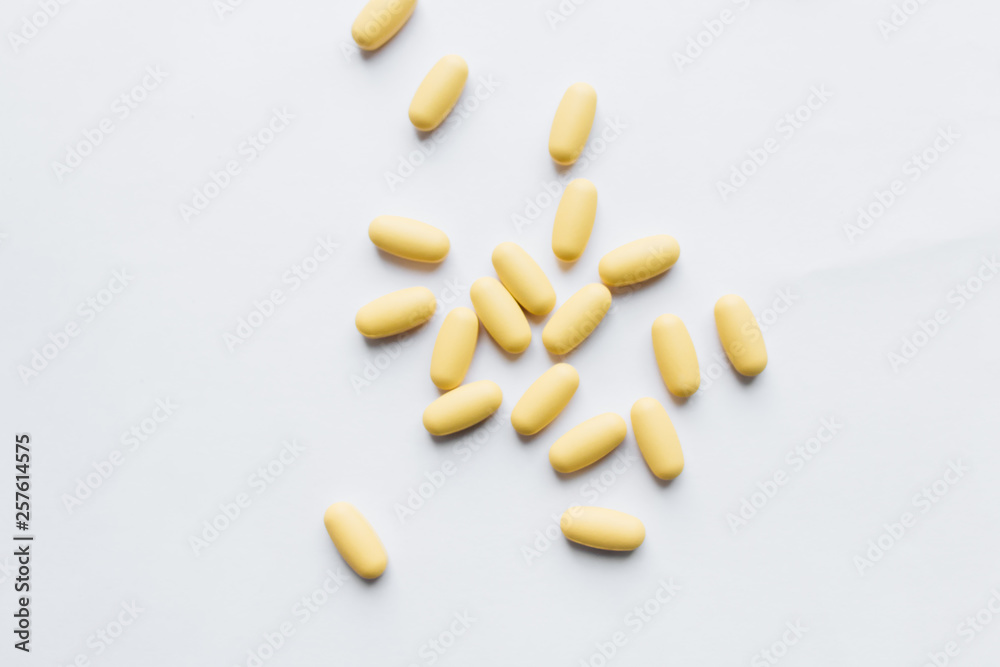 Scatterded yellow pills on white background Scatterded yellow pills on white background