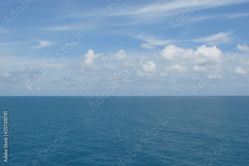 The panorama of the sea horizon, which connects the blue sky decorated with small white clouds, and the sea blue is decorated with a small ripple.