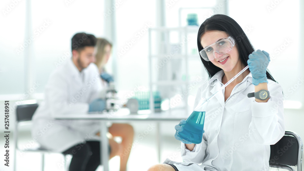 close up.female laboratory assistant takes a sample of the liquid close up.female laboratory assistant takes a sample of the liquid
