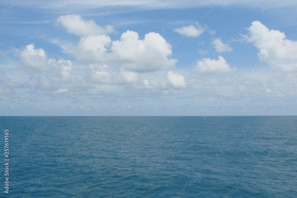 The panorama of the sea horizon, which connects the blue sky decorated with small white clouds, and the sea blue is decorated with a small ripple. The panorama of the sea horizon, which connects the blue sky decorated with small white clouds, and the sea blue is decorated with a small ripple.