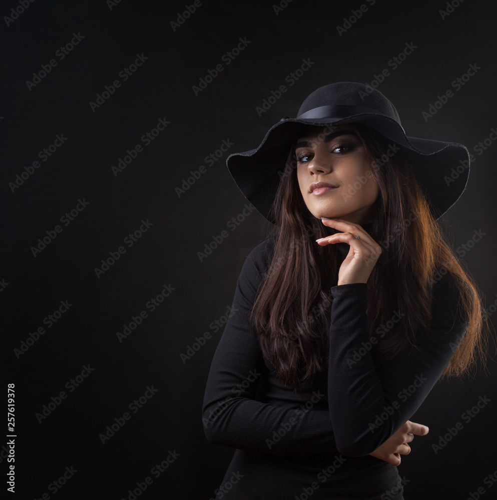 Brunette woman with long and shiny dark hair in a black Hat. Beautiful model on dark background. Studio photosession Brunette woman with long and shiny dark hair in a black Hat. Beautiful model on dark background. Studio photosession