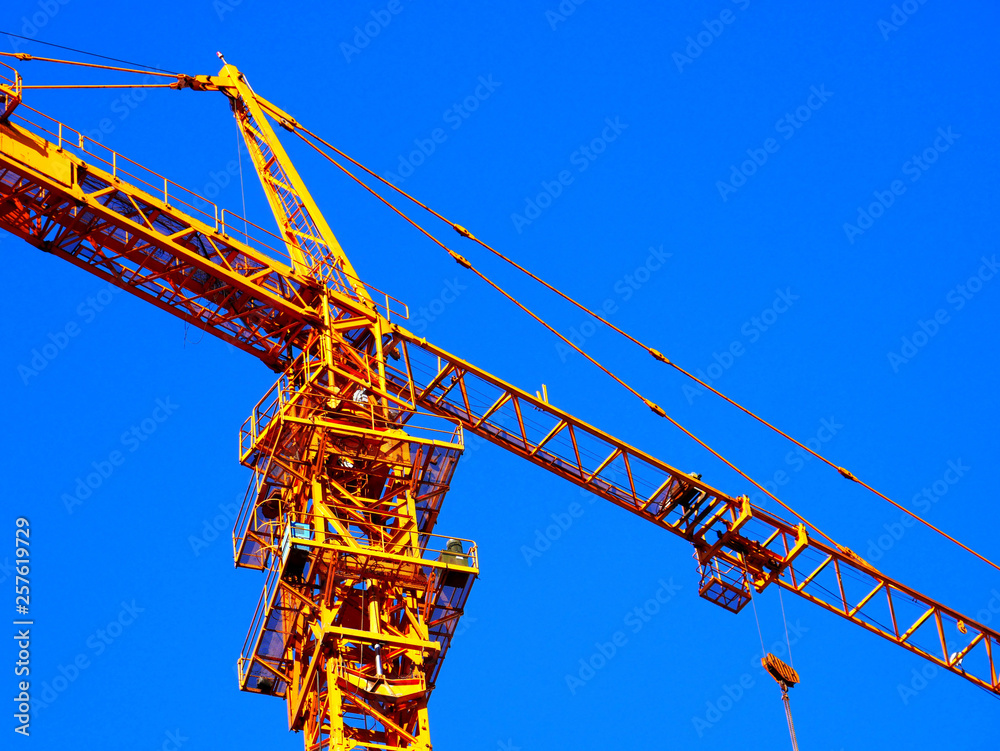 Crane. Self-erecting crane. Hoisting crane. Construction crane against blue sky. Crane. Self-erecting crane. Hoisting crane. Construction crane against blue sky.