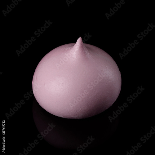 Pink meringue cookie isolated on black with reflection. photo