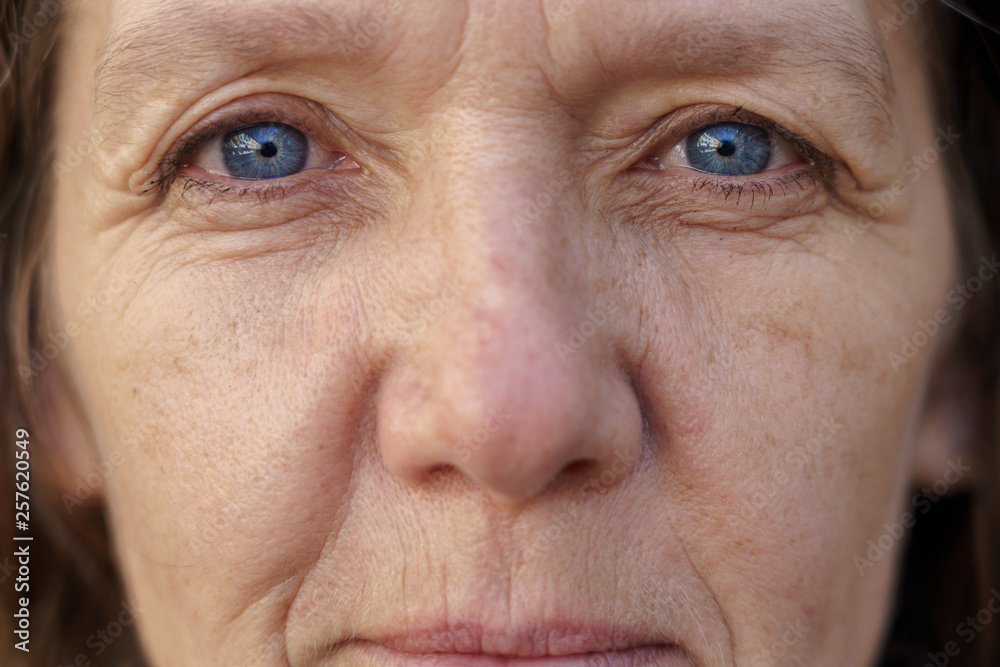 Cropped face of a blue-eyed middle-aged woman - obrazy, fototapety, plakaty 
