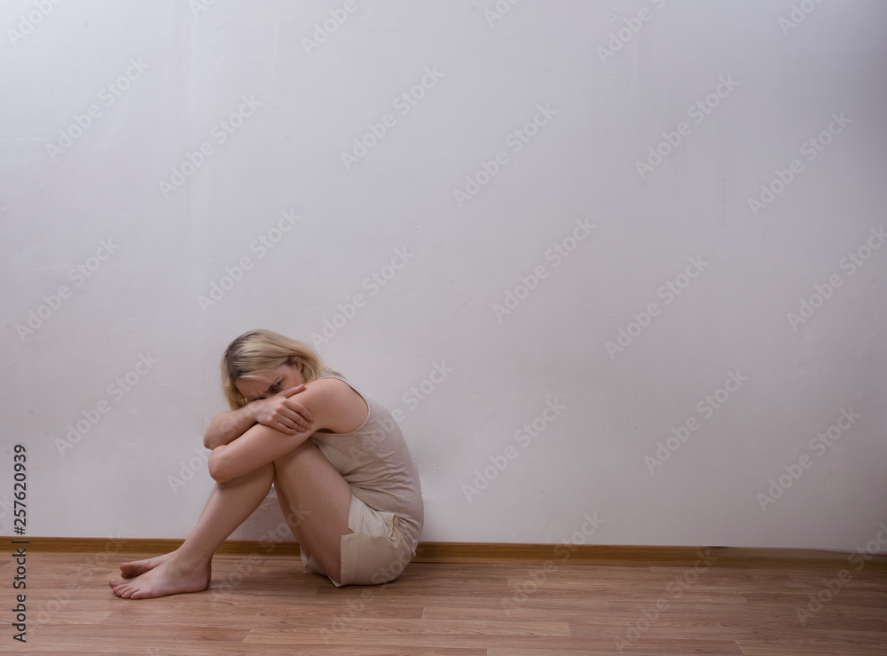 woman sitting on the floor and zakryvaet face with his hands. woman sitting on the floor and zakryvaet face with his hands.