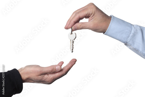 real estate concept: two men's hand giving and receiving keys isolated on white background with clipping path  included and copy space for your text