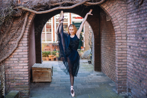 Young ballerina in ballet costume dancing and pointe shoes is in a beautiful pose   dancing on the street.  © olenap