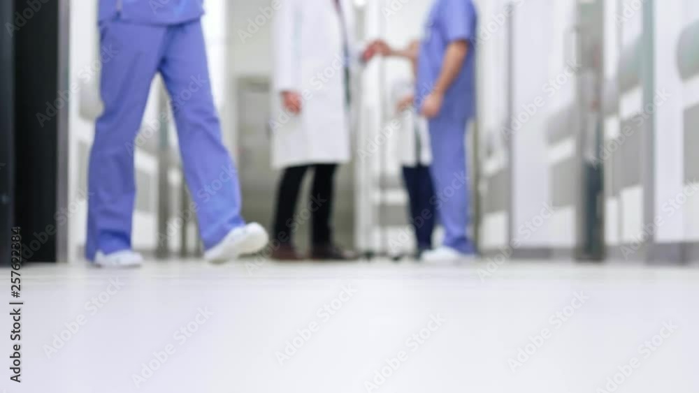 Part of doctors walking through corridor in hospital Part of doctors walking through corridor in hospital