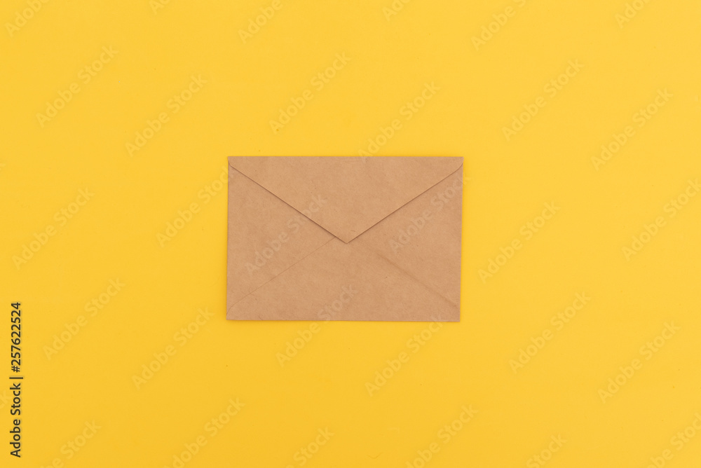 Kraft envelope on yellow background Kraft envelope on yellow background