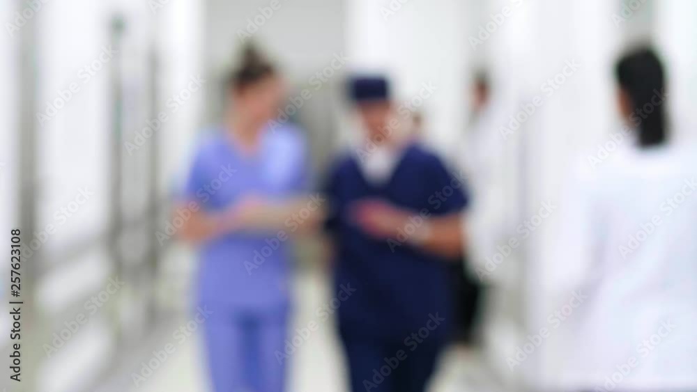 Blurred motion of doctors walking through corridor in hospital Blurred motion of doctors walking through corridor in hospital