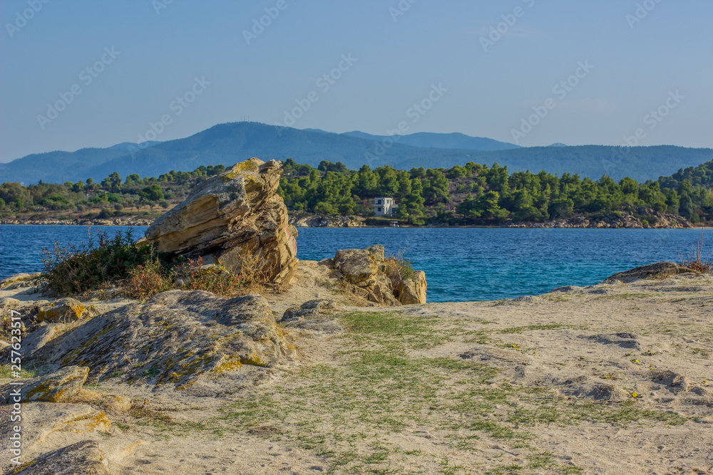 rocky stone Mediterranean sea lagoon waterfront coast line with opposite island view in summer bright weather time, vacation theme photography 