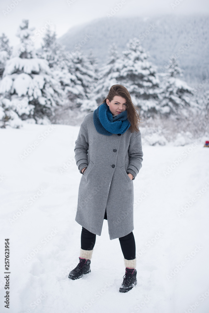 young woman on snow in greay coat young woman on snow in greay coat
