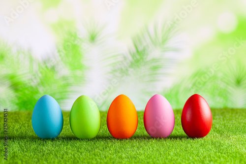 Happy Easter - Colored eggs on grass and green abstract background