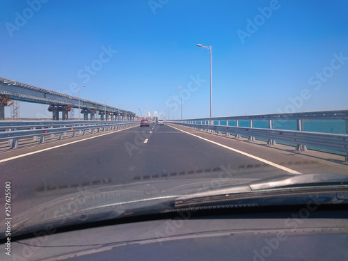 View through the windshield of a moving car. Crimea, Russia - June, 8, 2018: Travel on the Crimean bridge during its construction. View from the car