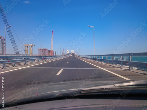 View through the windshield of a moving car. Crimea  Russia - June  8  2018  Travel on the Crimean bridge during its construction. View from the car