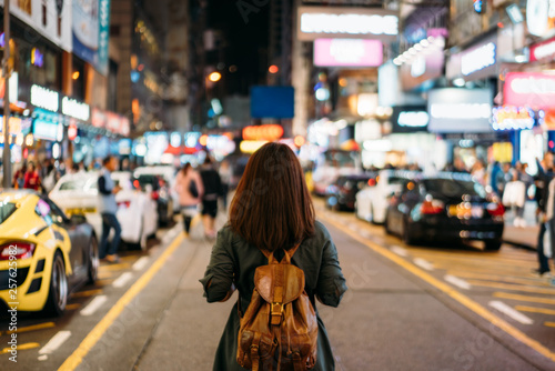 Young woman traveler traveling into Mongkok street market at night in Hong Kong China