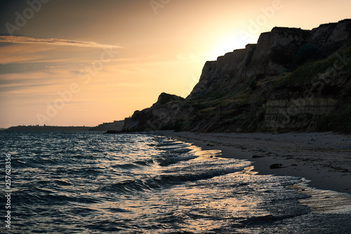 beautiful sunset, sea landscape, sea coast with high hills, wild nature