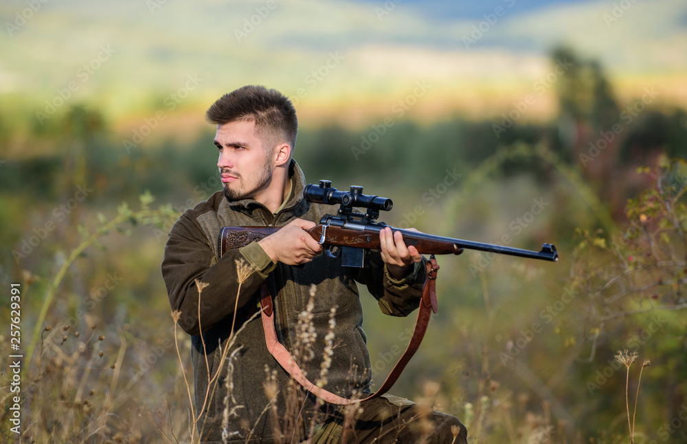 Hunting and trapping seasons. Hunting permit. Man brutal gamekeeper nature background. Bearded hunter spend leisure hunting. Hunter hold rifle. Focus and concentration of experienced hunter