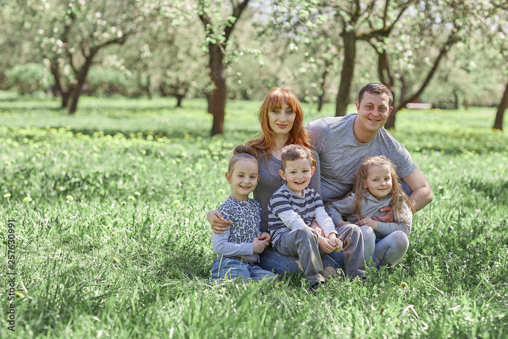 parents with their children sitting on the grass in the spring garden