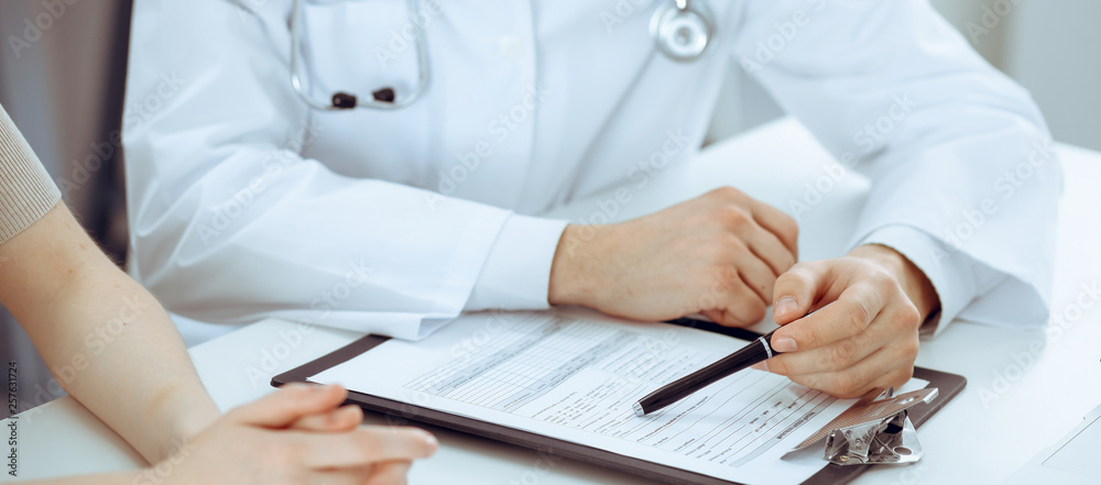 Doctor man and patient are discussing something, just hands at the table. Medicine and health care concepts Doctor man and patient are discussing something, just hands at the table. Medicine and health care concepts