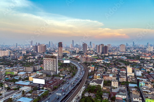 Cityscape of Bangkok city with low and hight building along the street with sky train on rail way.