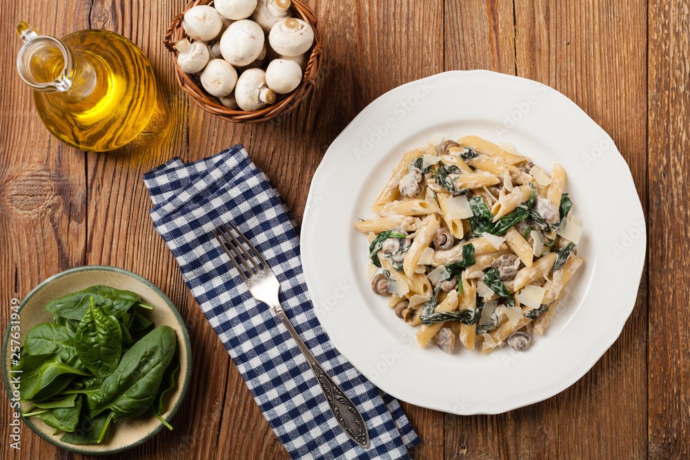 Penne pasta with spinach and mushrooms. Sprinkled with cheese. Penne pasta with spinach and mushrooms. Sprinkled with cheese.