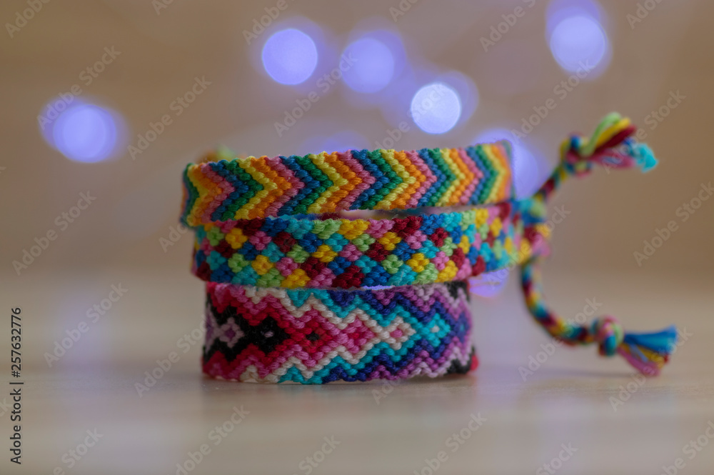 Bracelet of friendship, colorful woven friendship bracelets on wooden table