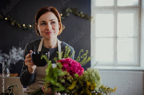 Young creative woman in a flower shop. A startup of florist business. photo