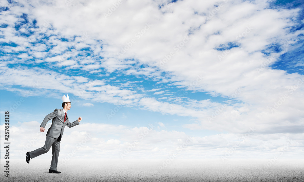 King businessman in elegant suit running and blue sky at background King businessman in elegant suit running and blue sky at background