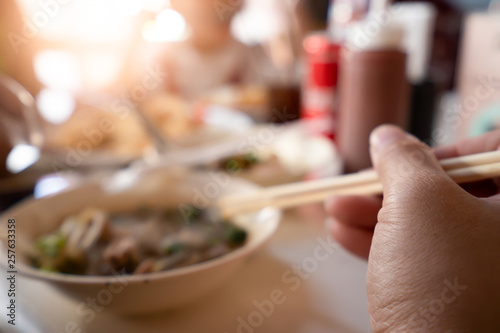 Hand holding chopsticks for eating noodles