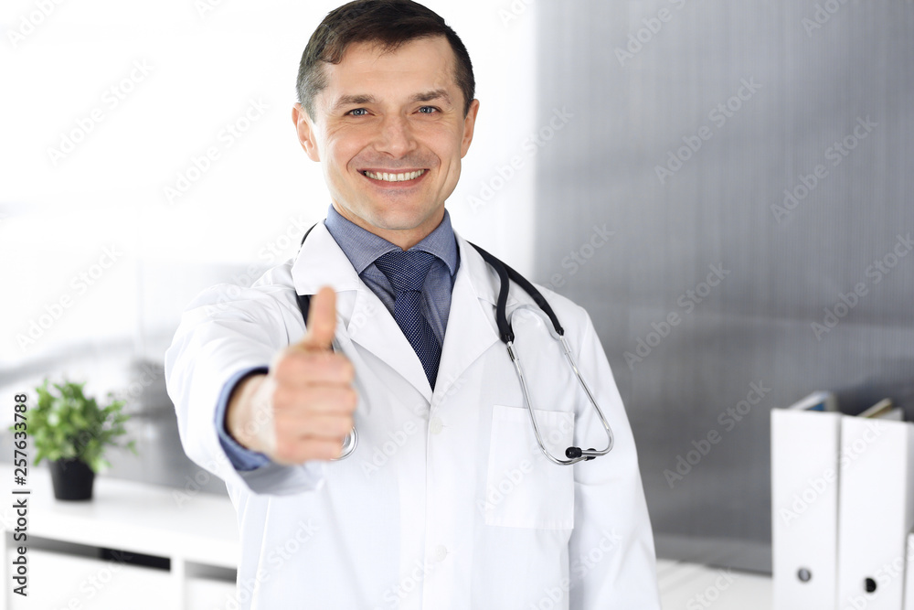 Doctor man cheerful smiling at camera, thumbs up. Perfect medical service in clinic. Happy future in medicine and healthcare Doctor man cheerful smiling at camera, thumbs up. Perfect medical service in clinic. Happy future in medicine and healthcare