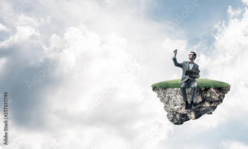 Young businessman or student floating in sky and studying the science