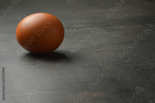 Single egg on the black wood background with copy space