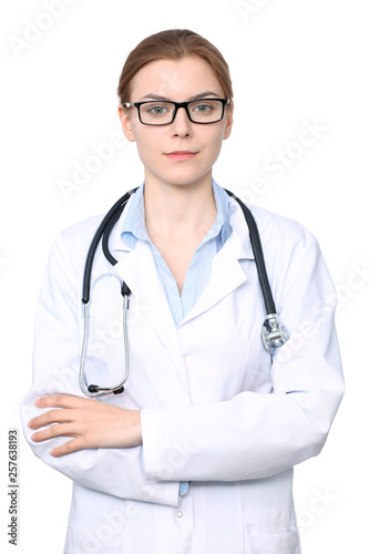 Young brunette female doctor standing with arms crossed. Isolated over white background