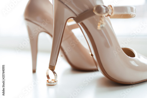 wedding rings on the background of the bride's shoe
