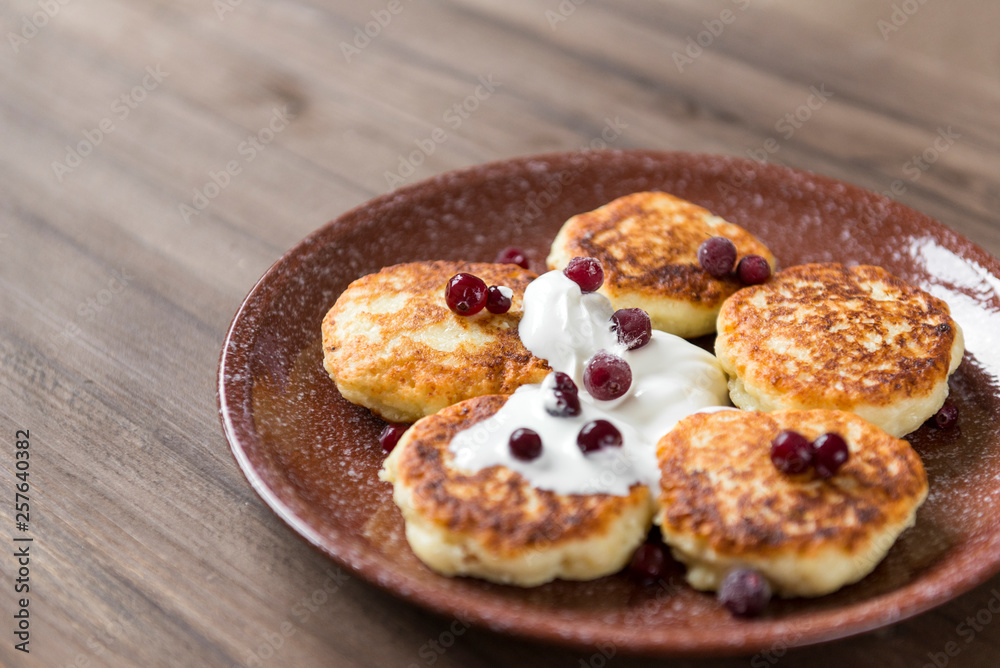 cheesecakes with sour cream and cranberries, pancakes with berries
