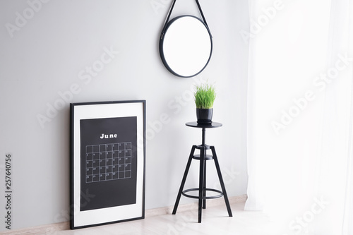 Calendar and stool near lig...