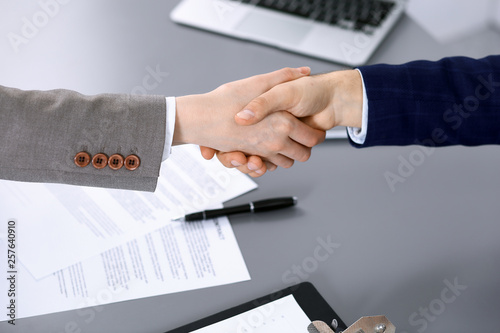 Business people shaking hands, finishing up a meeting. Papers signing, agreement and lawyer consulting concept