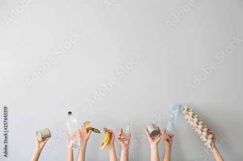 Hands with different types of garbage on white background