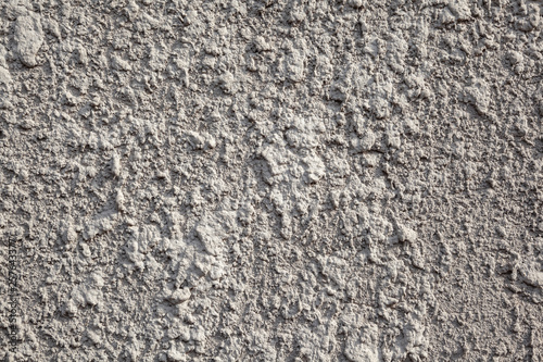 The close up texture of the plastered facing of the stone surface of the wall.