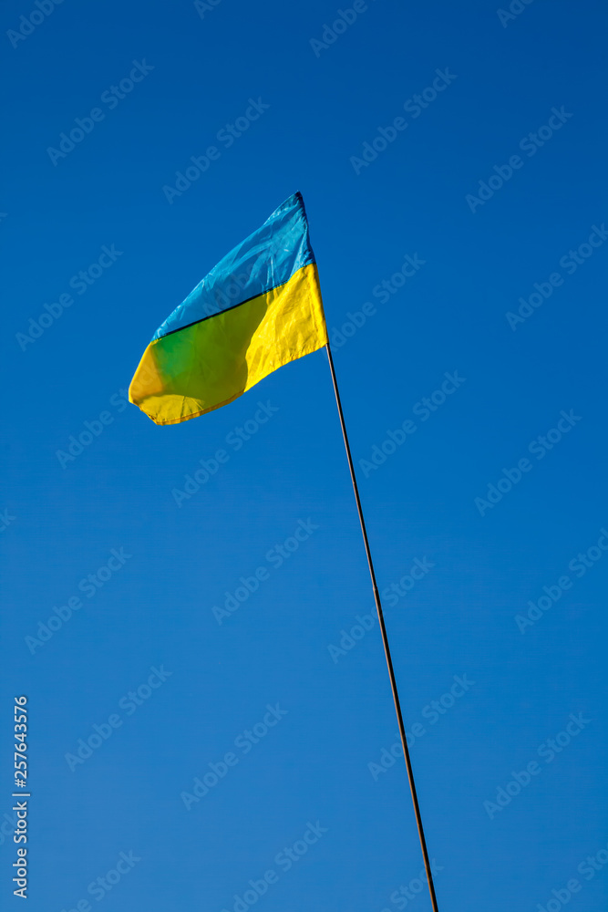 Ukrainian flag flies against blue sky background. Ukrainian flag flies against blue sky background.