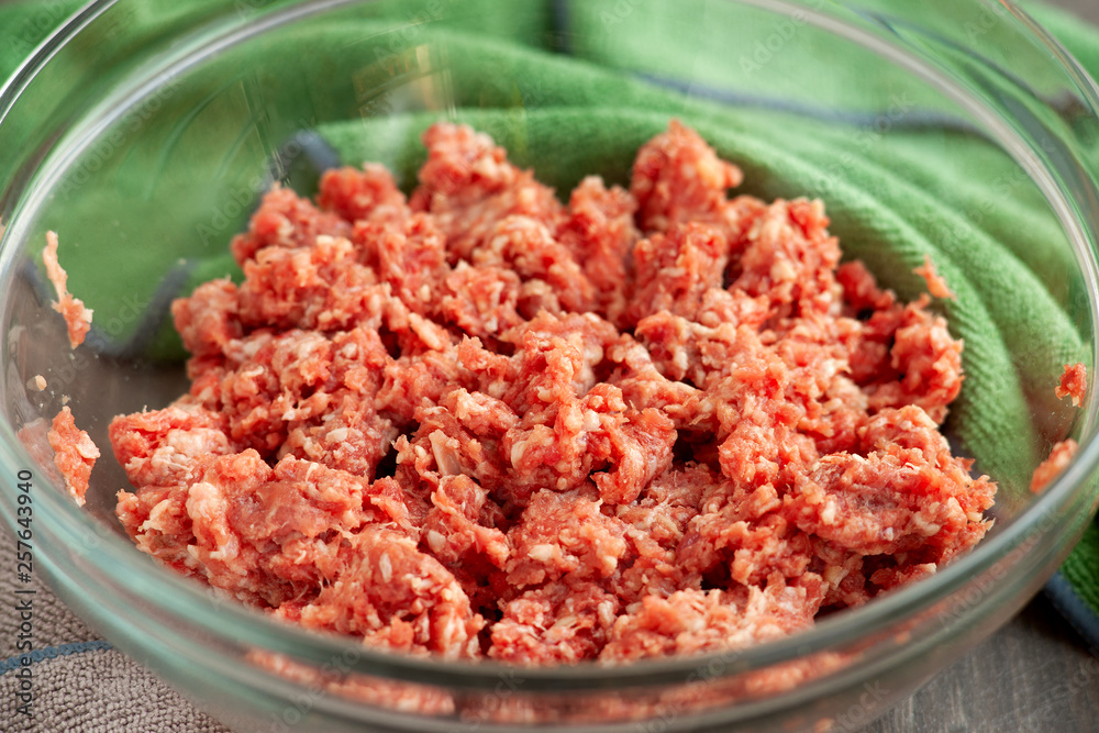 Minced meat is depicted in close-up. Minced beef and pork in a bowl for cooking. Lots of ground beef in glass dishes in the kitchen. Minced meat is depicted in close-up. Minced beef and pork in a bowl for cooking. Lots of ground beef in glass dishes in the kitchen.