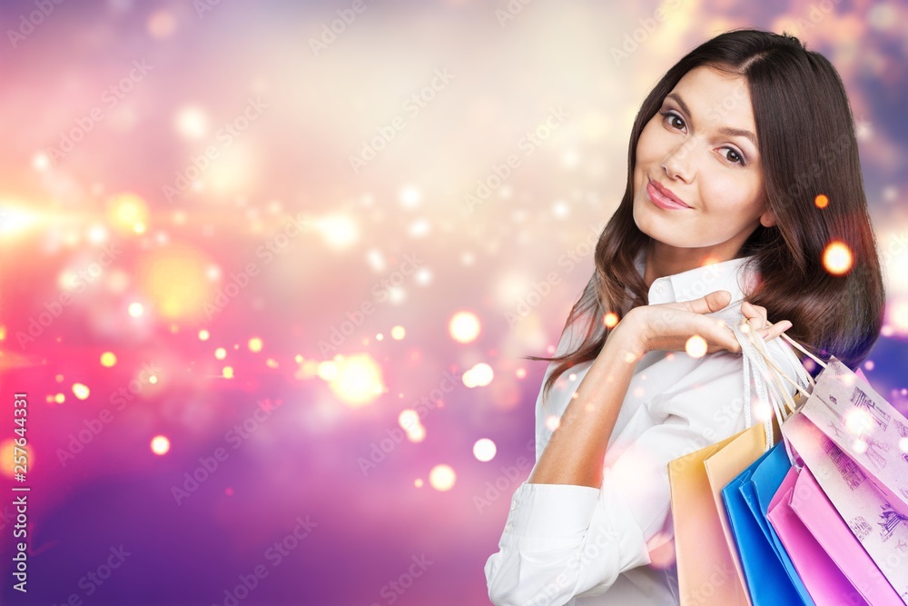 Young woman with shopping bags on blurred shopping mall background Young woman with shopping bags on blurred shopping mall background