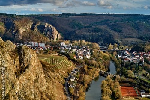 scenic aerial view from the rock Rotenfels down to the river Nahe and the small city of Bad Muenster am Stein-Ebernburg with vivid cloudy sky, the rock Rheingrafenstein can be seen in background