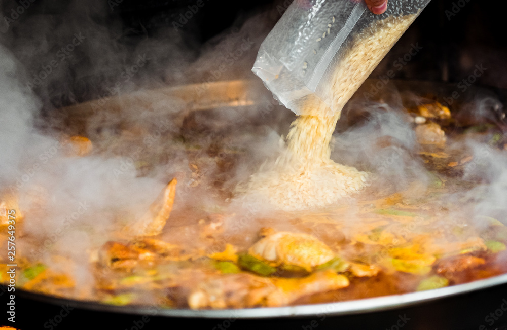 Cooking and making a traditional Spanish Paella over open fire. Cooking and making a traditional Spanish Paella over open fire.