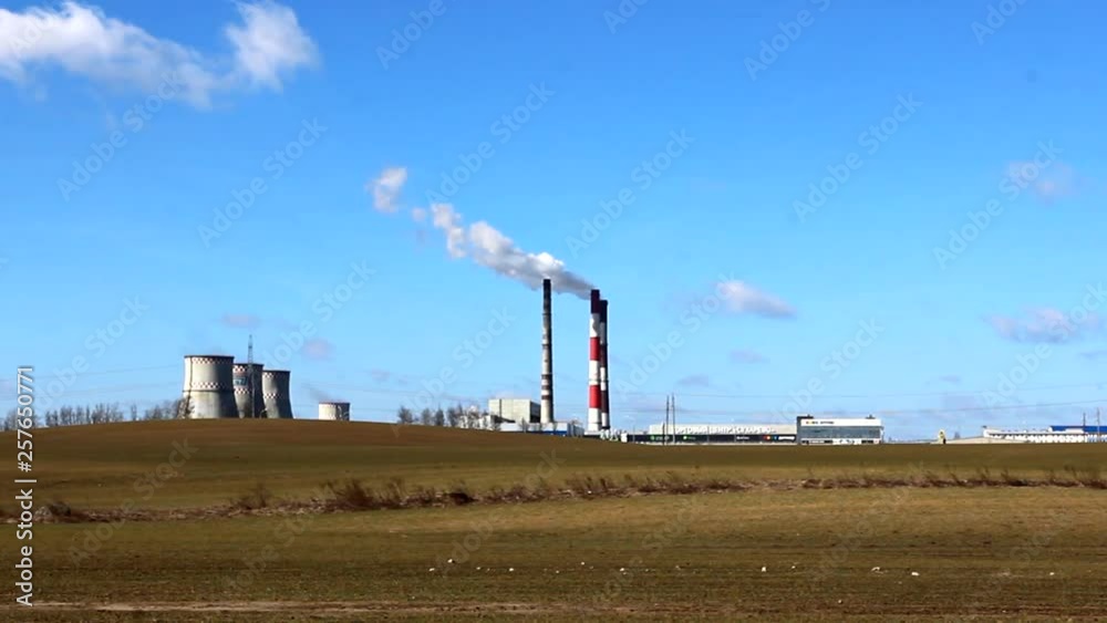 Industrial zone with a large red and white pipe thick white smoke is poured from the factory pipe. Pollution of the environment: a pipe with smoke. in Minsk. Air pollution on the outskirts of the city Industrial zone with a large red and white pipe thick white smoke is poured from the factory pipe. Pollution of the environment: a pipe with smoke. in Minsk. Air pollution on the outskirts of the city
